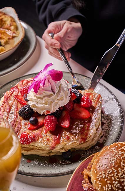 ERA Cafe in Waunakee, WI A person enjoys berry-topped pancakes at Breakfast Brunch & Lunch in Waunakee Wisconsin.
