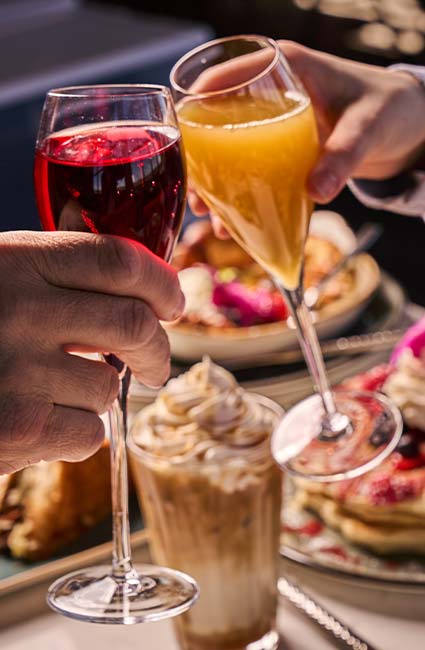 ERA Cafe in Waunakee, WI Two hands toast vibrant drinks over brunch at Breakfast Brunch & Lunch in Waunakee Wisconsin.